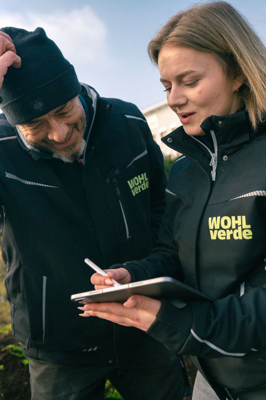 Zwei WOHLverde-Mitarbeitende dokumentieren eine Objektkontrolle auf dem Tablet