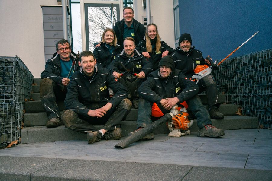Gruppenfoto des WOHLverde-Teams vor einem Bürogebäude